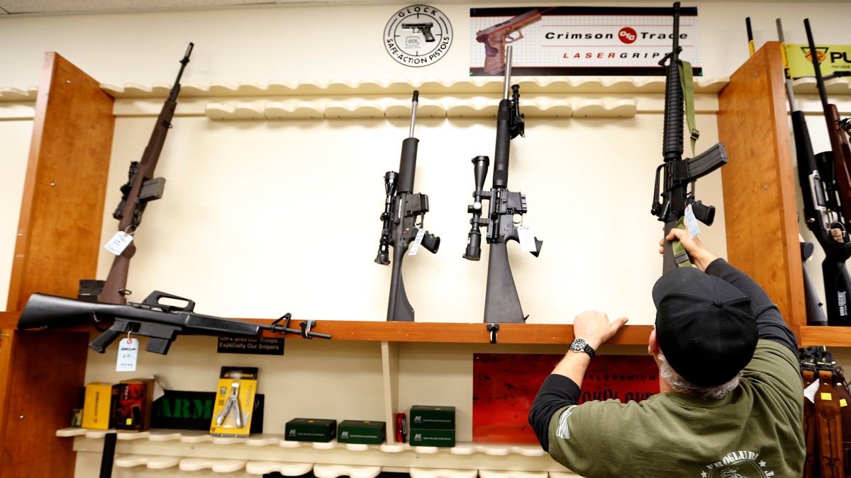  File photo of Mike Fiota, Duke's Sport Shop store manager, replacing one of the five military style rifles available into the rack that usually has more than 20 new models for sale in New Castle, Pa. (AP Photo/Keith Srakocic) 