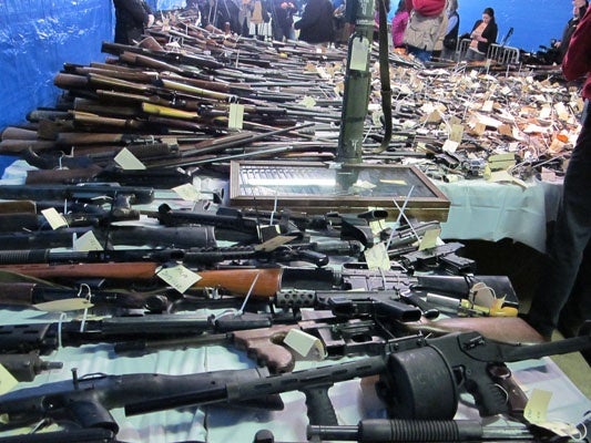 <p>A 'street sweeper" shotgun with cartridge capable of hold 12 rounds of ammunition (foreground) and an antique Uzi (in case) are among the weapons collected at the Trenton buyback program. (Phil Gregory for NewsWorks)</p>
