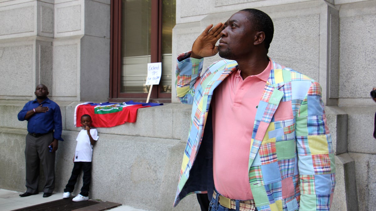  Haitians salute as their country's flag is raised in front of City Hall during Haitian Flag Day,  May 18. The federal government has extended temporary protected status  for Haitians living in the U.S. (Emma Lee/WHYY, fie) 