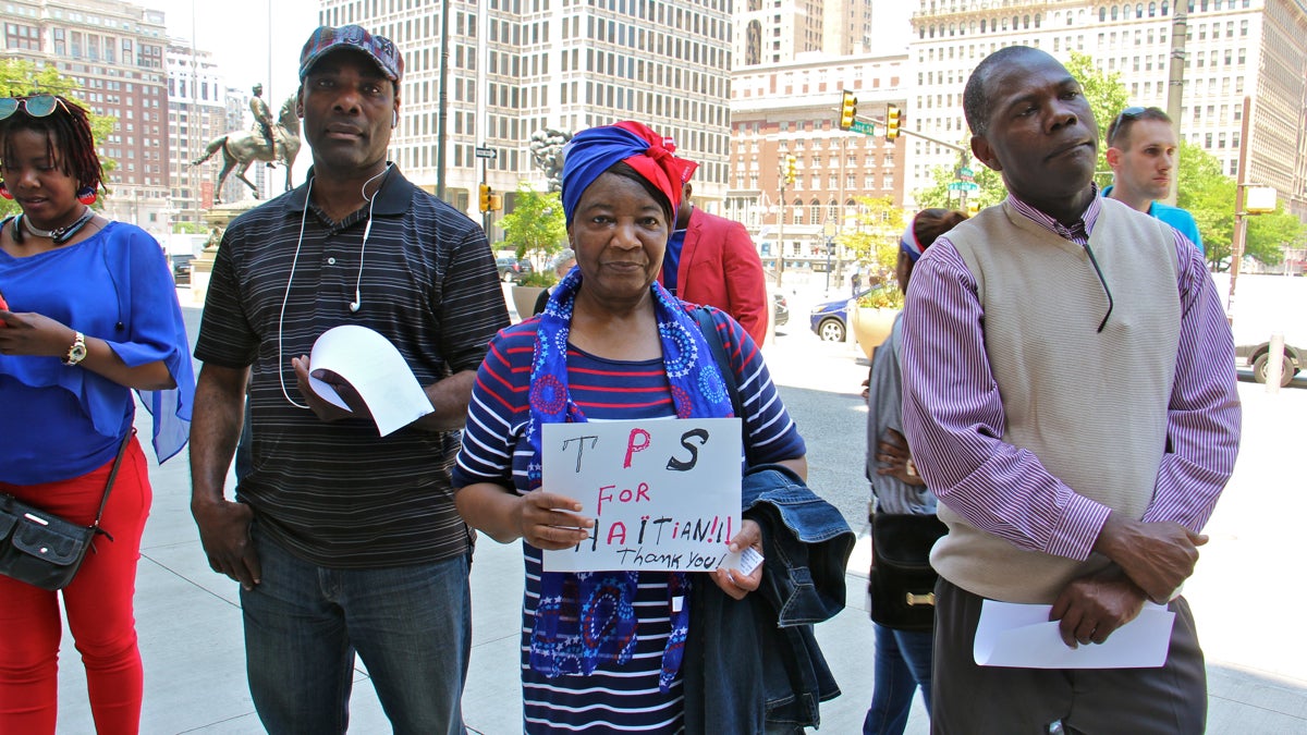  Marie Belfort (center) and other Haitian Philadelphians gather outside City Hall to celebrate Haitian Flag Day and call for an extension of temporary protected status for Haitians, which expires July 22. TPS allows Haitians to remain and work legally in the United States. (Emma Lee/WHYY) 