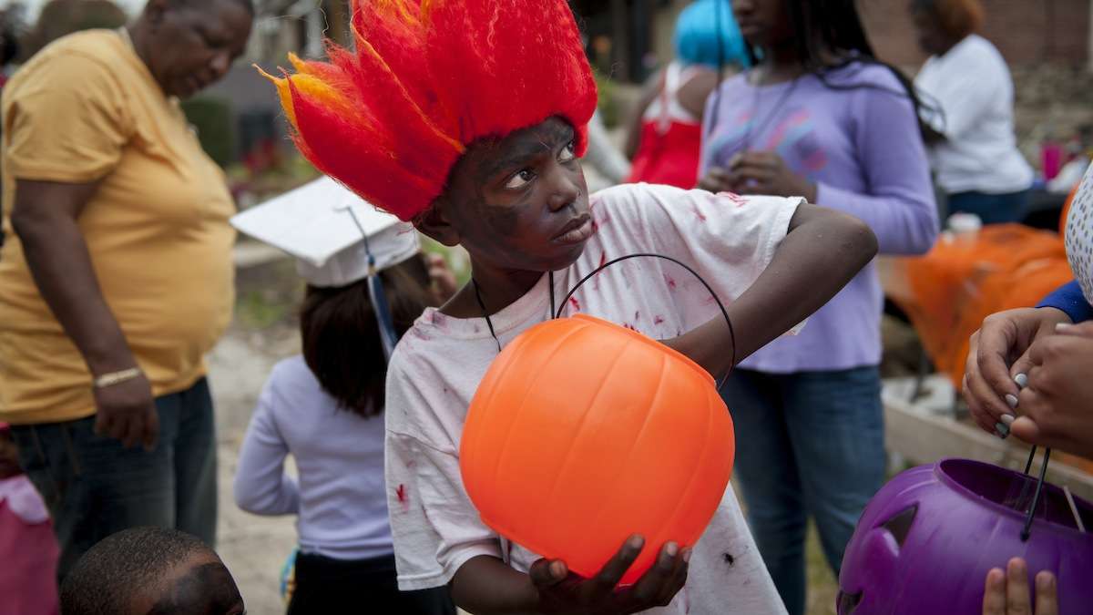 Kevon Lewis, 9, of Germantown, loaded candy into a pumpkin to be given away as prizes at the Halloween party for West Rockland Street in Germantown on Halloween night. (Tracie Van Auken/for NewsWorks)