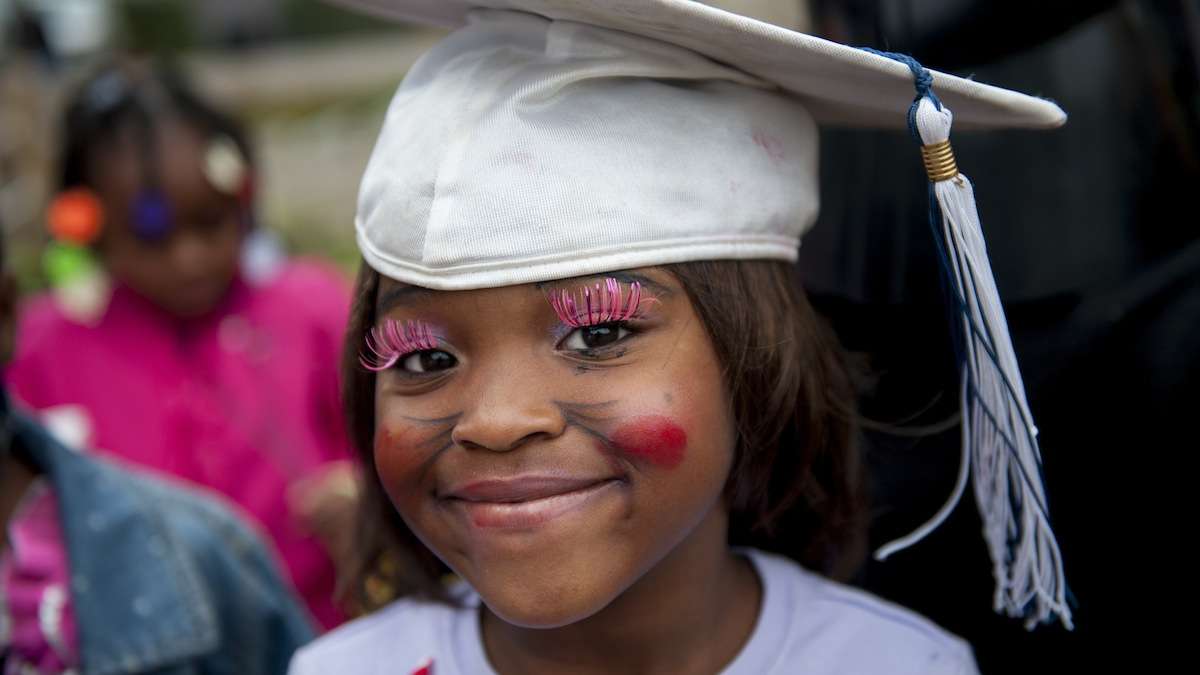 Chiani Reed, 5, wears pink lashes and a graduation cap to the West Rockland Street Halloween party on Halloween night. (Tracie Van Auken/for NewsWorks)