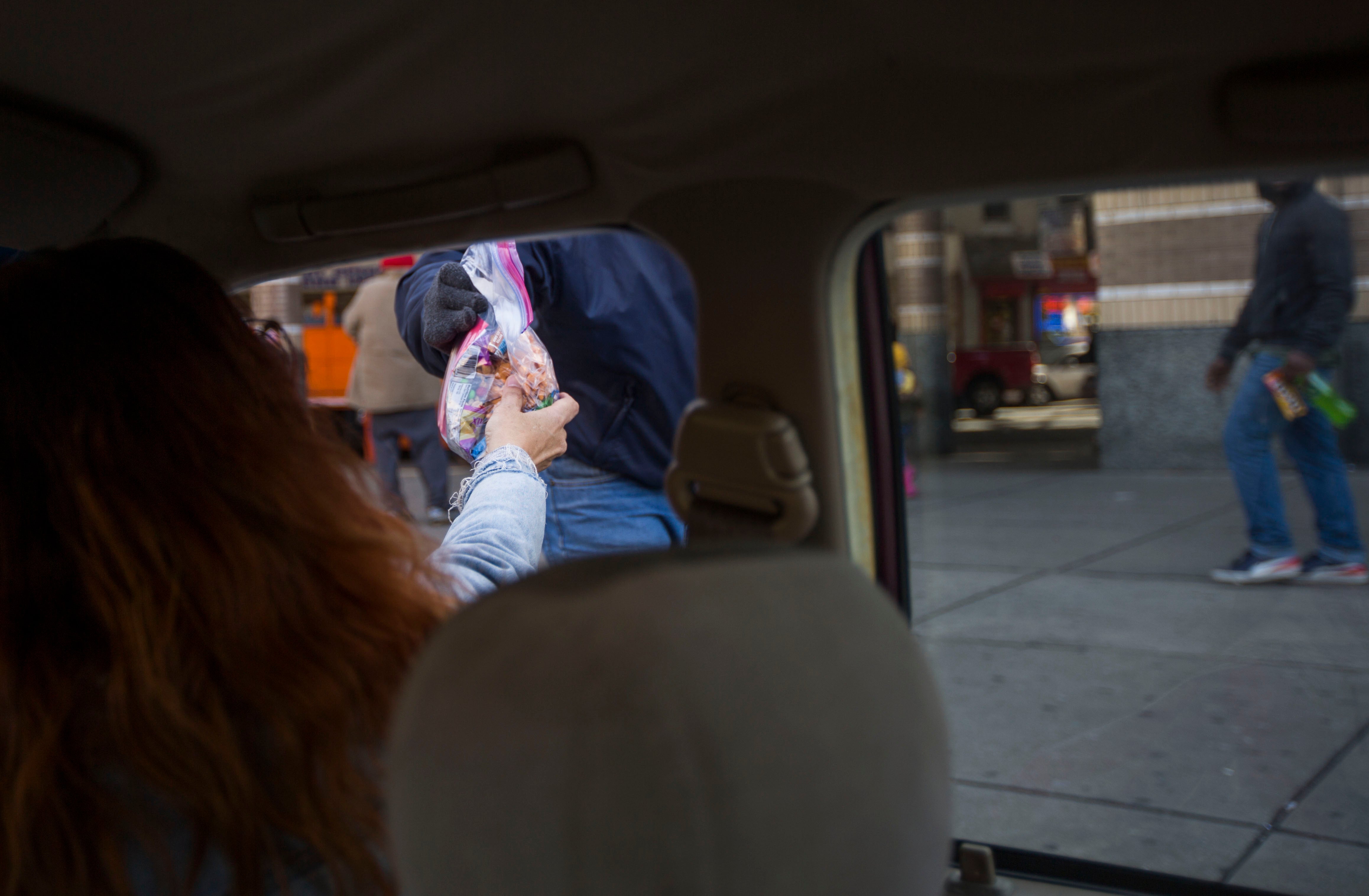 Barb Burns hands out bags of food. (Jessica Kourkounis/For Keystone Crossroads)