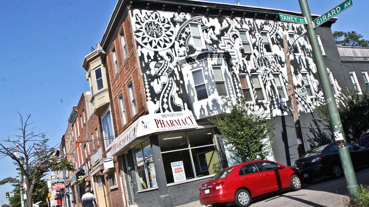 A mural by Aindriais Dolan, also known as Pure TFP, on a building owned by NMMPartners on Girard Avenue. (Kimberly Paynter/WHYY)