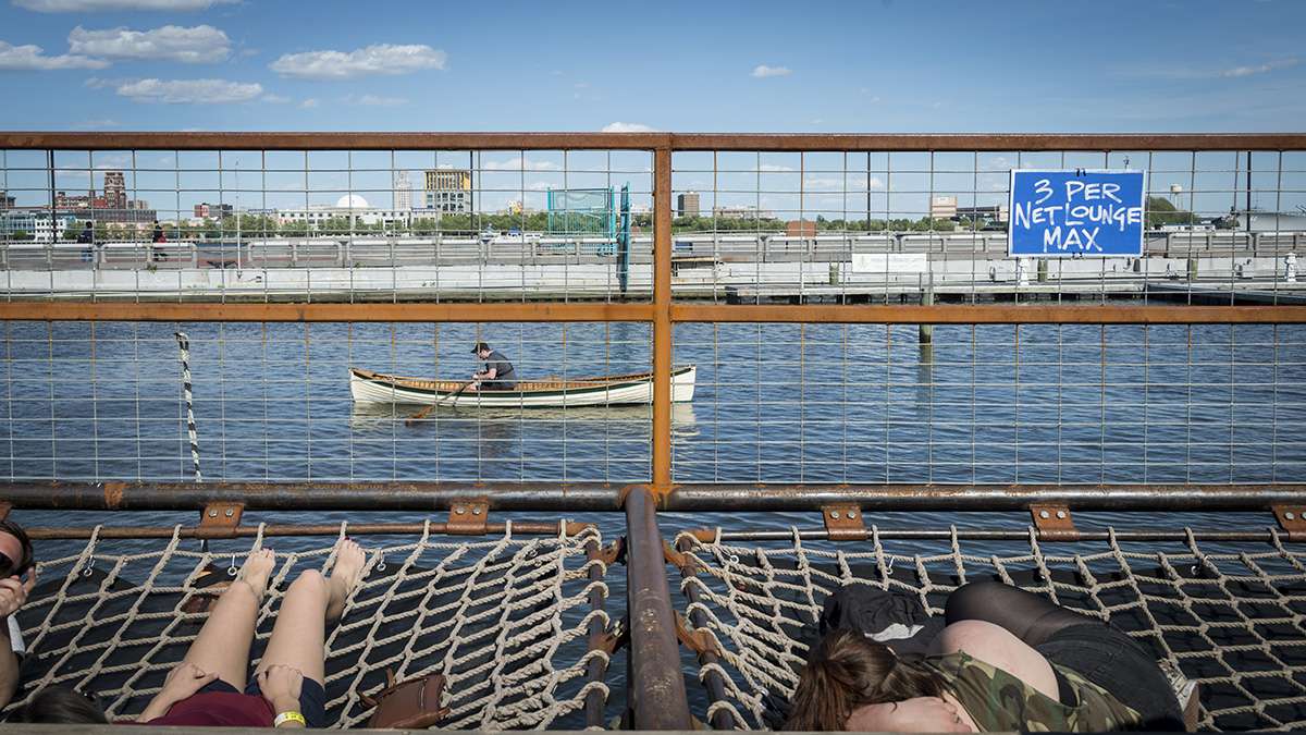 Visitors to Spruce Street Harbor Park sunbathe in nets strung over the water.