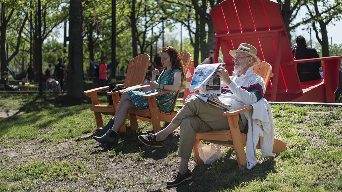 Jay Chaplan reads a newspaper on the banks of the Delaware River during opening weekend of the Spruce Street Harbor Park.