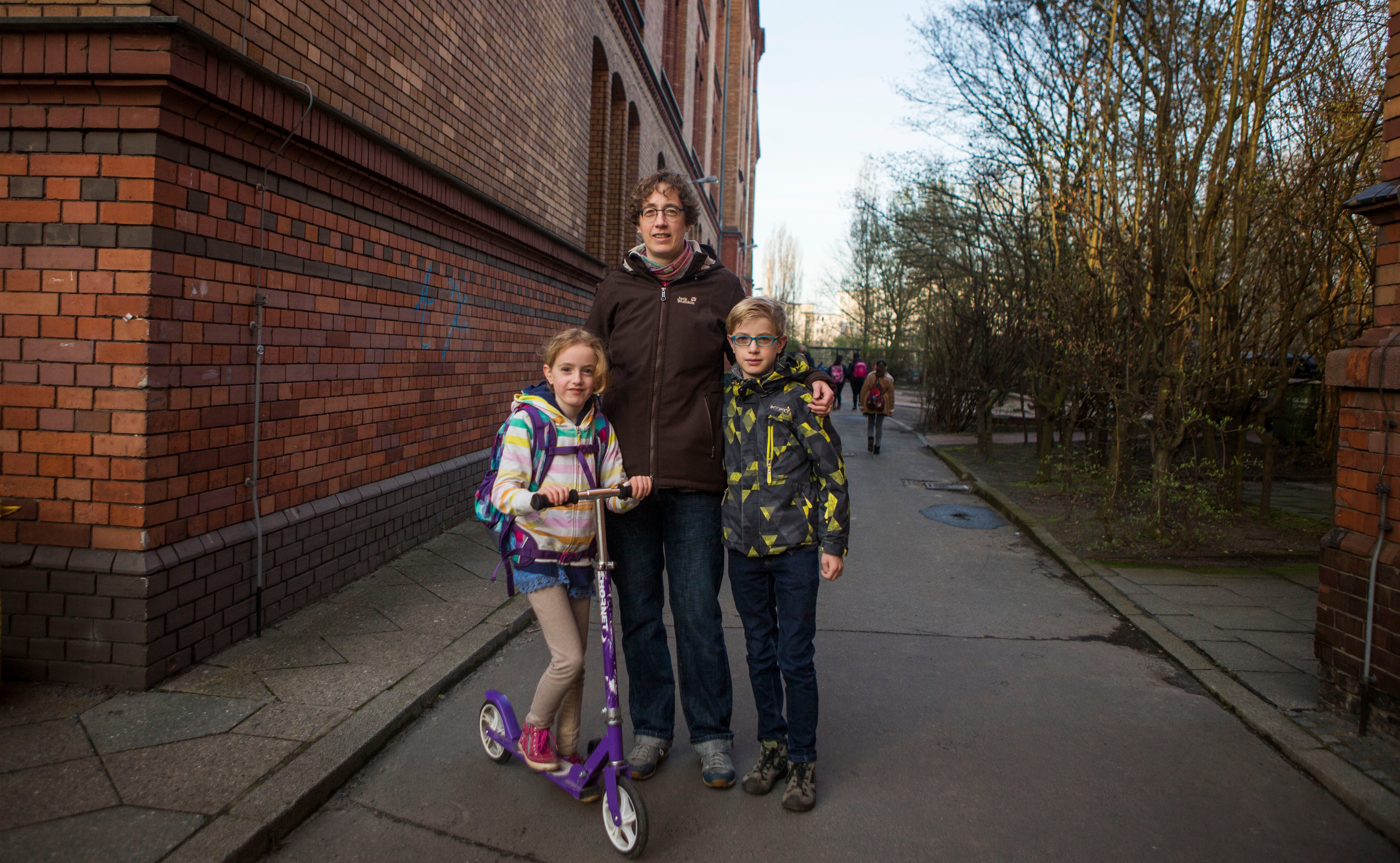 <b> 'Loopholes': </b> Heike Mohaupt-Wonnemann (center) and her children Ulrike (left) and Harold (right) Wonnemann, outside of Gustav Falke elementary school in Wedding, Berlin, Germany. (Jessica Kourkounis/For Keystone Crossroads)