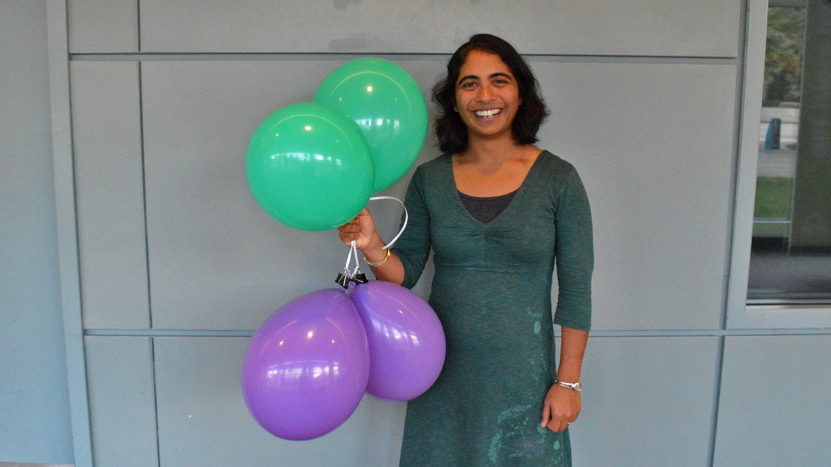  Franklin Institute chief bioscientist Jayatri Das  holds green balloons full of helium, and purple balloons full of sulfur hexaflouride. (Paige Pfleger/WHYY) 
