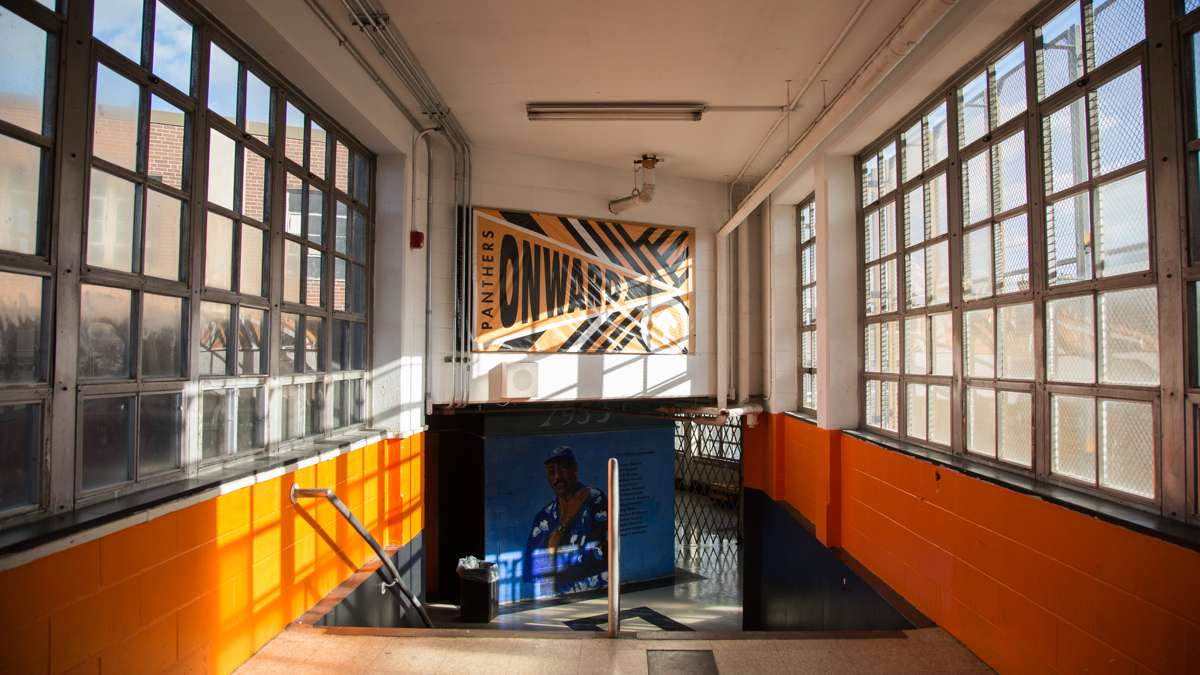 The passageway to the gym is covered in paintings done by the students at Overbrook High School. (Emily Cohen for NewsWorks)