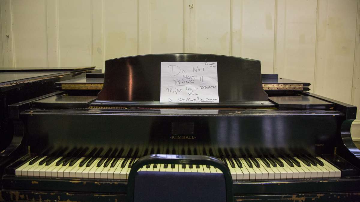 A broken piano sits in the auditorium since the music program was cut from Overbrook High School. (Emily Cohen for NewsWorks)