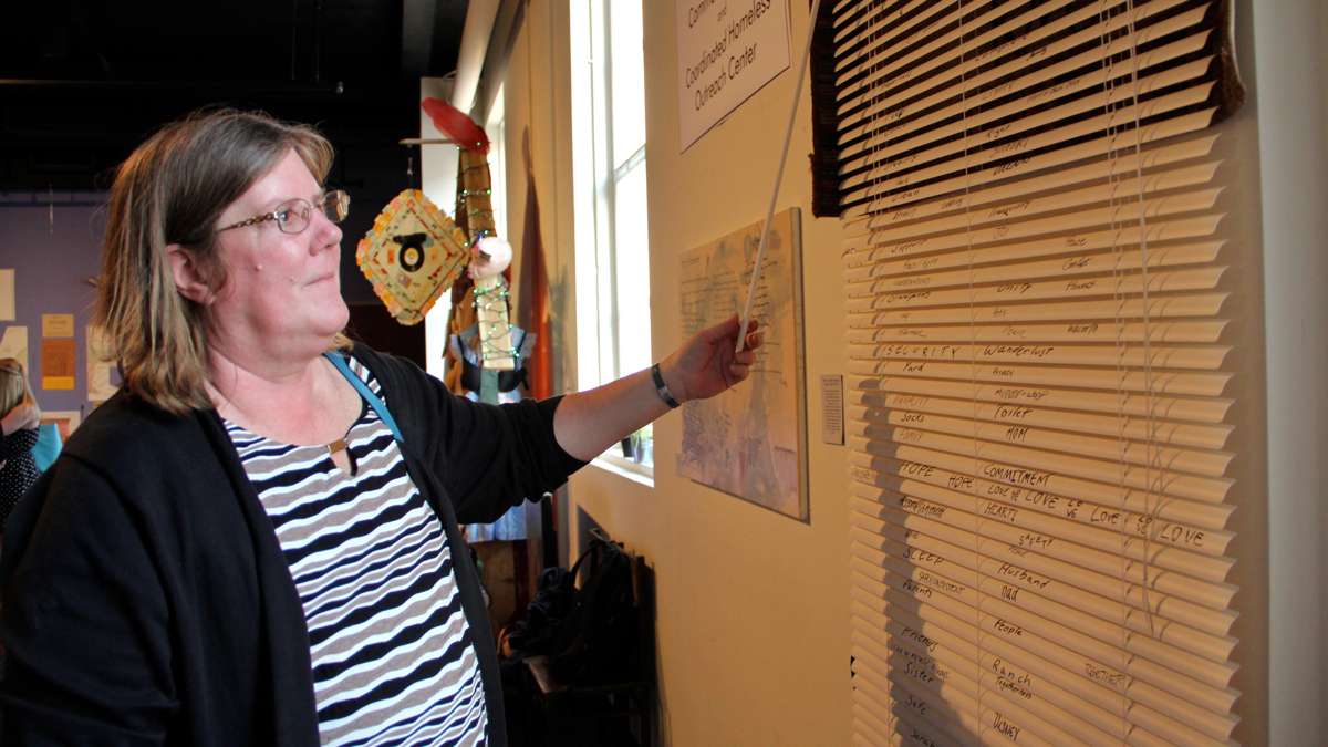 Genny O'Donnell, director of the Coordinated Homeless Outreach Center, looks at an art installation at Theatre Horizon in Norristown. (Emma Lee/WHYY)