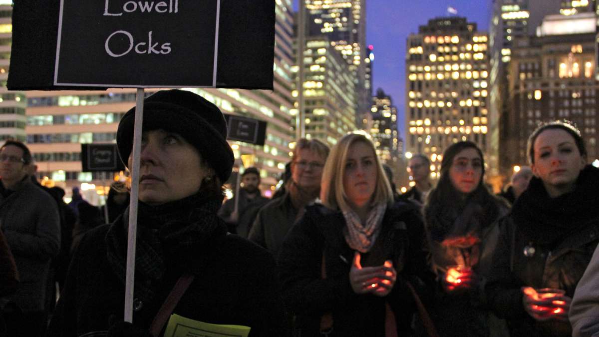 With signs and candles, Philadelphians gather at Thomas Paine Plaza to remember the homeless who died in 2013. (Emma Lee/for NewsWorks)
