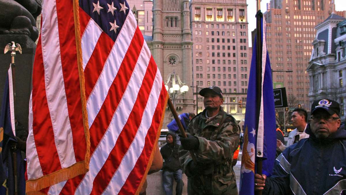 Veteran Eric Taylor, who says he was homeless for four years, carries the flag in honor of the homeless who have died, and his fellow veterans. (Emma Lee/for NewsWorks)