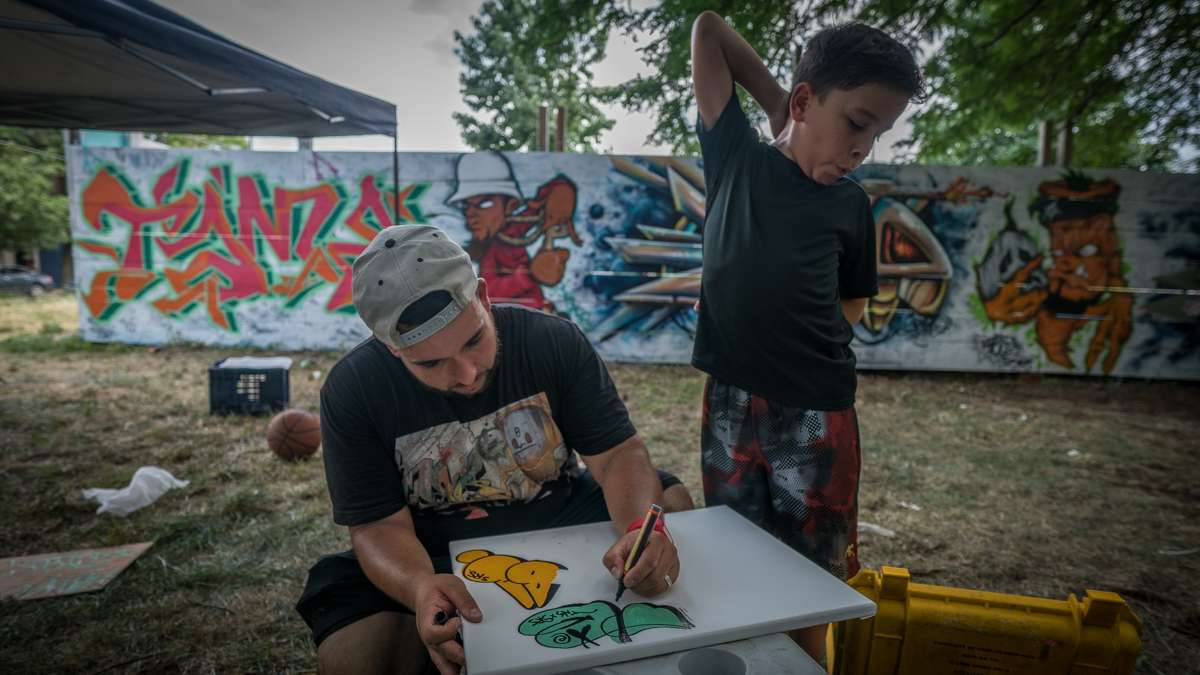 Life Do Grow Farm Art Director Chris Rodriguez works on a drawing while his son Brian looks on