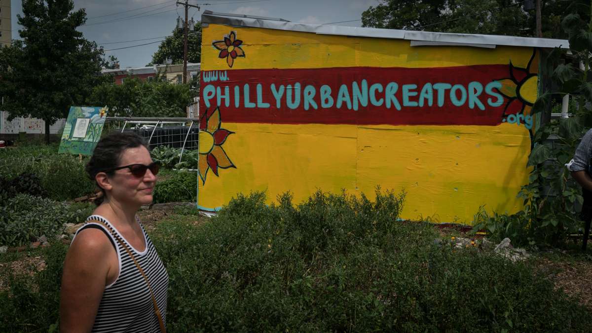 A festival goer passes a structure promoting Philly Urban Creators, the group that hosts the annual Hoodstock Festival in North Philadelphia, July 22, 2017.