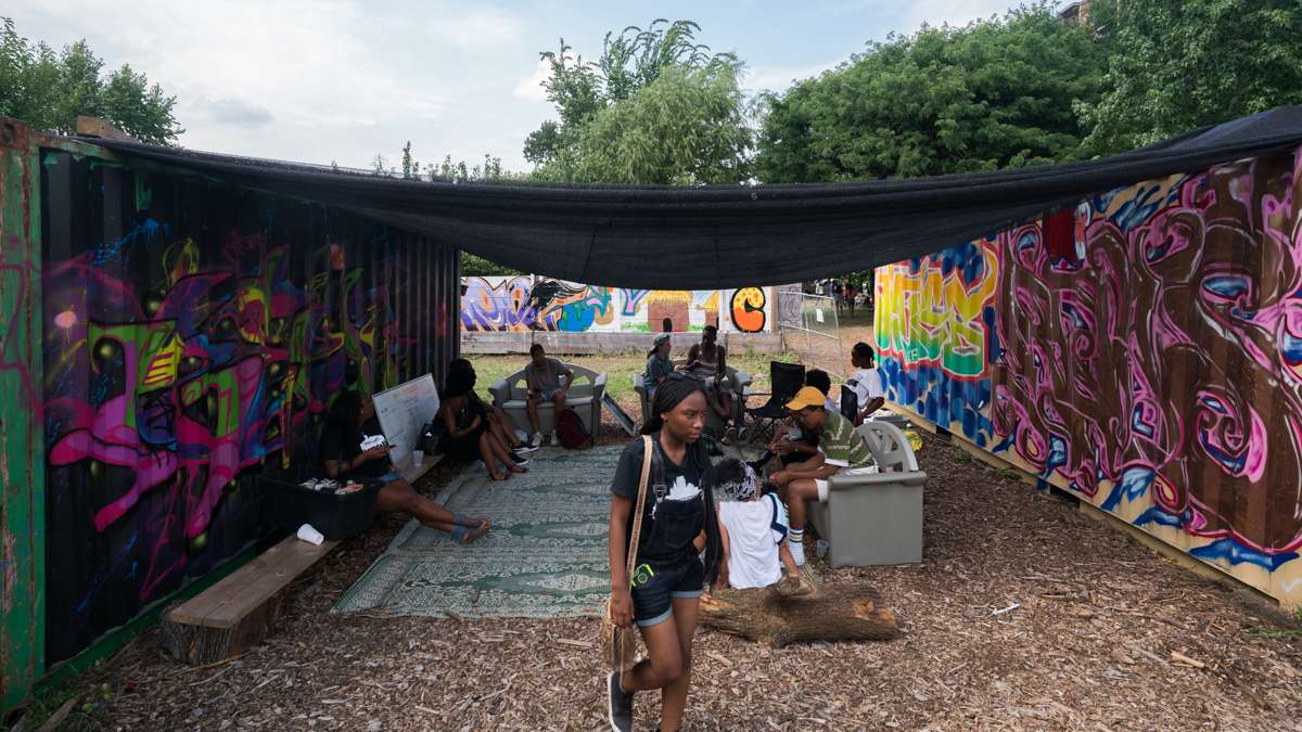 Festival goers relax in the shade