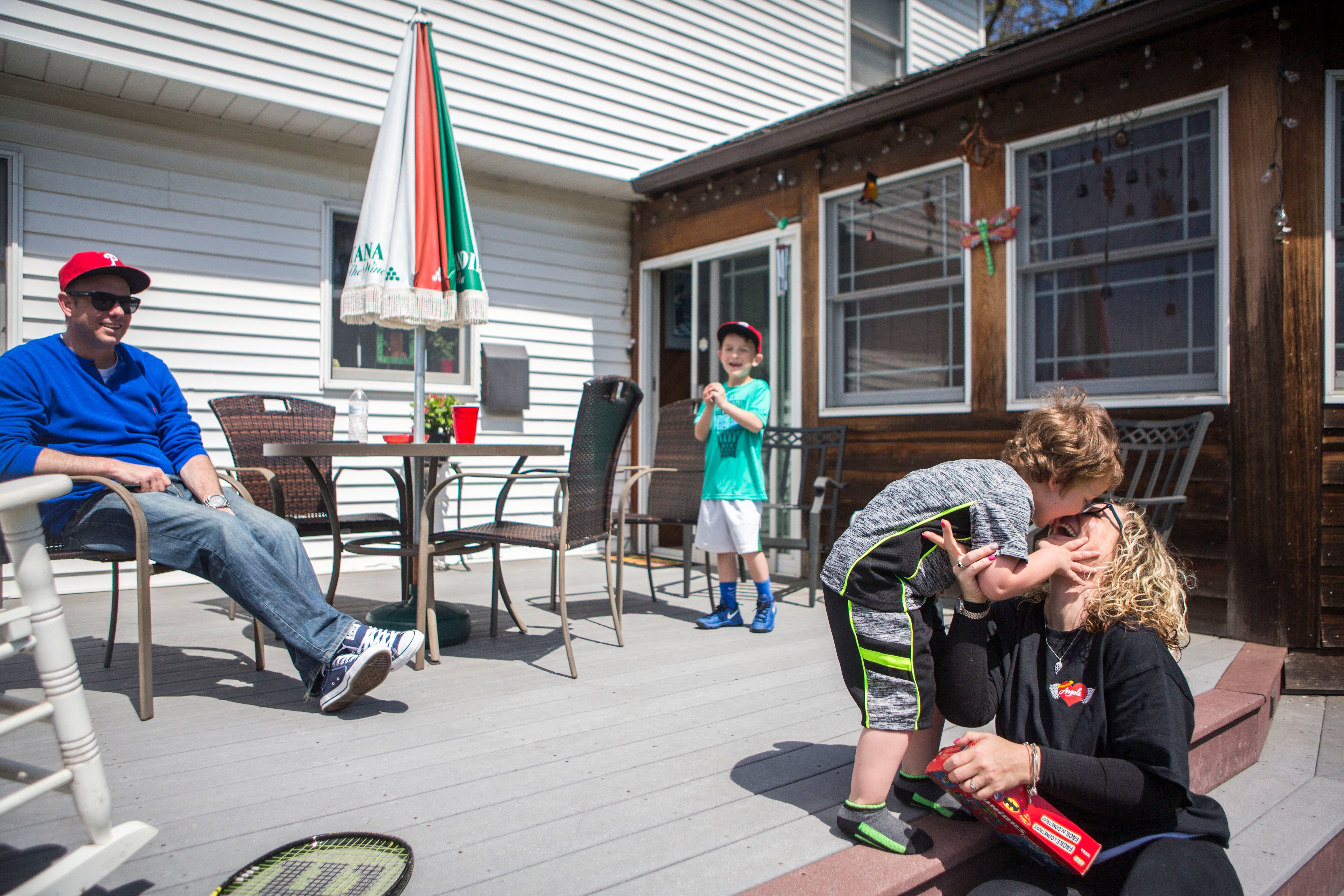 Nicole O'Donnell (right) spends a Sunday at her parent's home in Delaware County, Pennsylvania with her son Joey, her fiancé Bill Meighan, and his son Ryan. (Jessica Kourkounis/For Keystone Crossroads)
