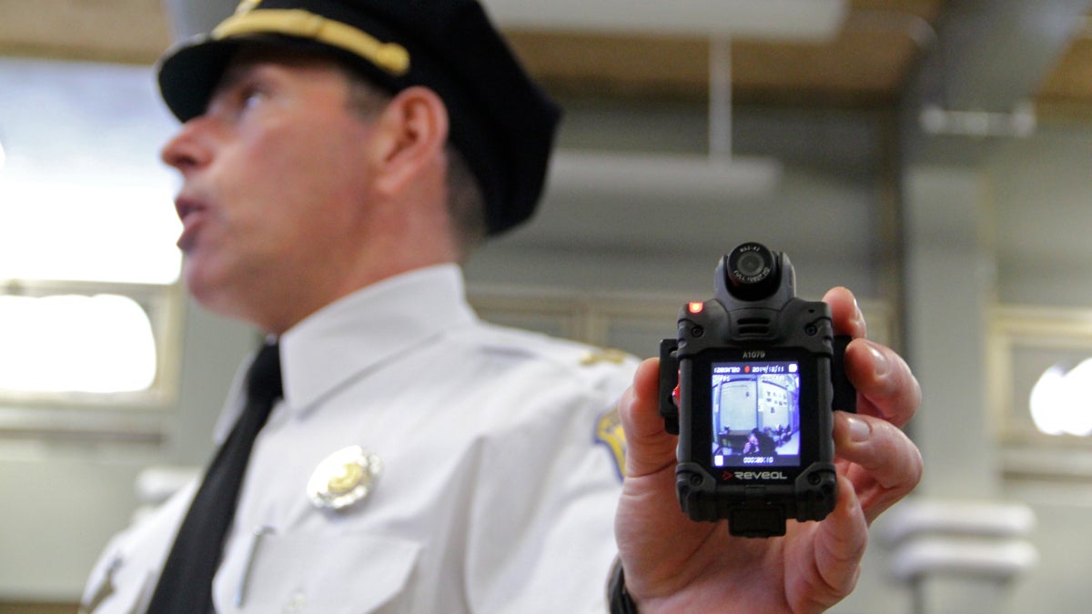 Lt. Tom McLean holds one of the many body camera models the police department is testing. (Emma Lee/WHYY)