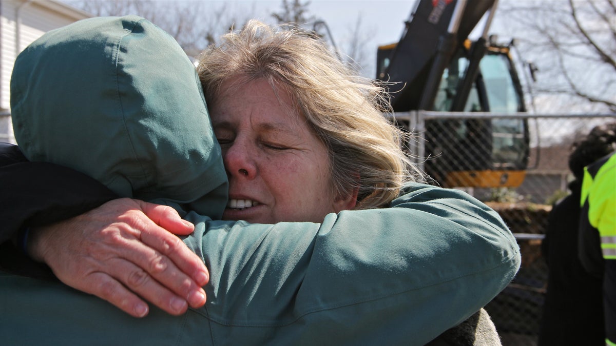  After watching her former home flattened, Theresa Kuczynski embraces Amy Sumoski, a case worker for the Blue Acres program, which purchases Sandy-damaged homes in flood-prone areas and demolishes them. (Emma Lee/for NewsWorks) 