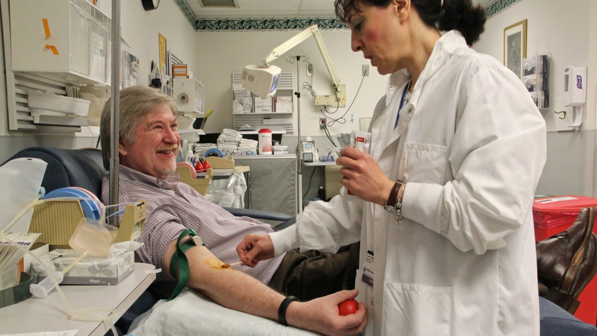 Charge nurse Lorri Summers prepares Dr. Craig Hooper for his weekly blood draw at Jefferson blood clinic. (Emma Lee/for NewsWorks)