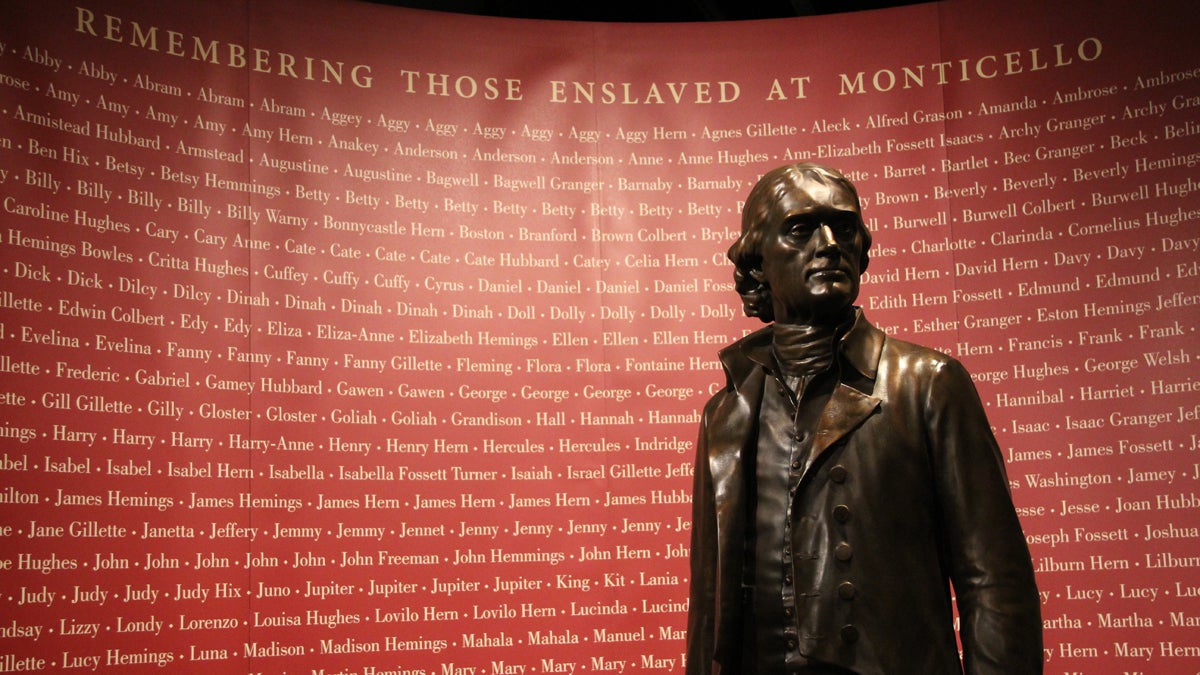  At the National Constitution Center in Philadelphia, a statue of Thomas Jefferson stands before a list of names of those who were slaves at Monticello. (Emma Lee/for NewsWorks) 