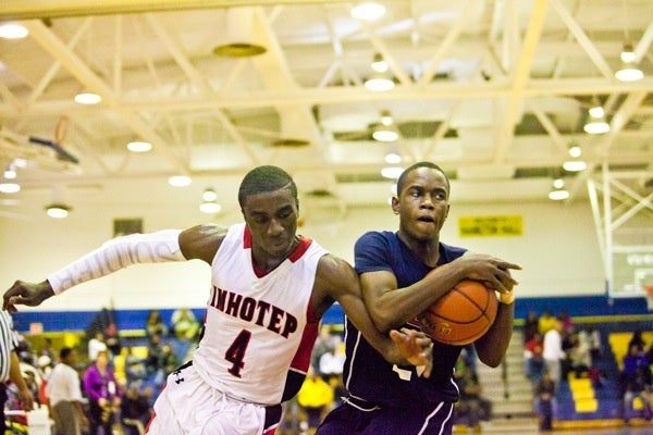 Abraham Massaley of Imhotep tries to strip the ball from James Bishop during Imhotep's 51-43 win Saturday. (Brad Larrison/for NewsWorks)
