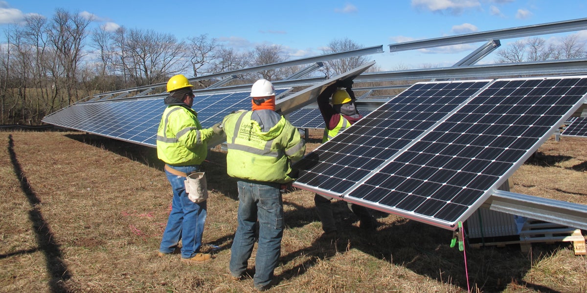 Workers install solar panels at  Delaware Valley Regional High School in Frenchtown, New Jersey. (Phil Gregory/WHYY) 