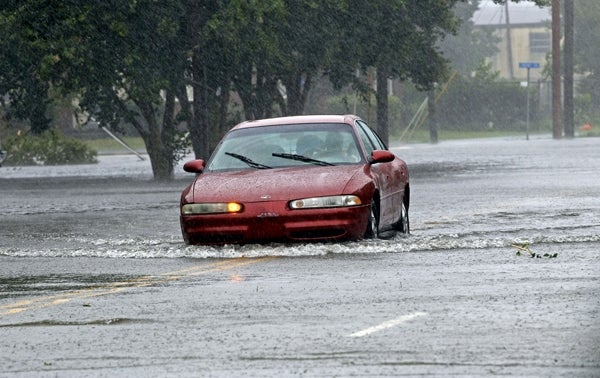 A man drives his car through a flooded street in New Bern, N.C. With flooding likely here, area motorists have been warned to never drive into standing water. (AP Photo/Chuck Burton)