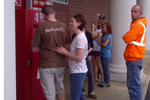 Some people turned to movies ahead of Hurricane Irene's visit.  A small line formed at the $1 DVD rental stand as some look to keep busy while waiting out the hurricane. (Tom MacDonald/For NewsWorks)