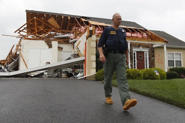 A member of the Delaware State Police walks away from a house that was heavily damaged by a possible tornado in Lewes, Del., Sunday, Aug. 28, 2011, after Hurricane Irene churned along the Delaware coast overnight. (AP Photo/Patrick Semansky)