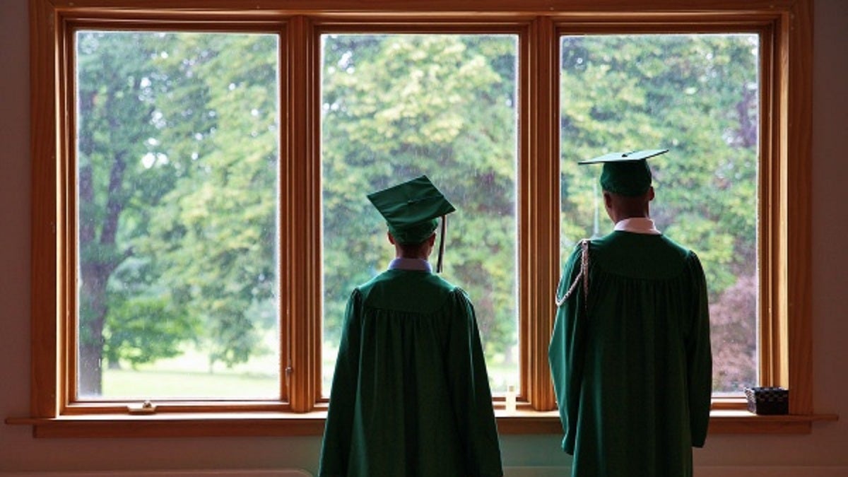  Two members of Germantown's Class of 2012 looked out the windows of New Covenant Church at last year's commencement. This year's ceremony will take on an aura of finality as the school will close on Friday. (Bas Slabbers/for NewsWorks) 