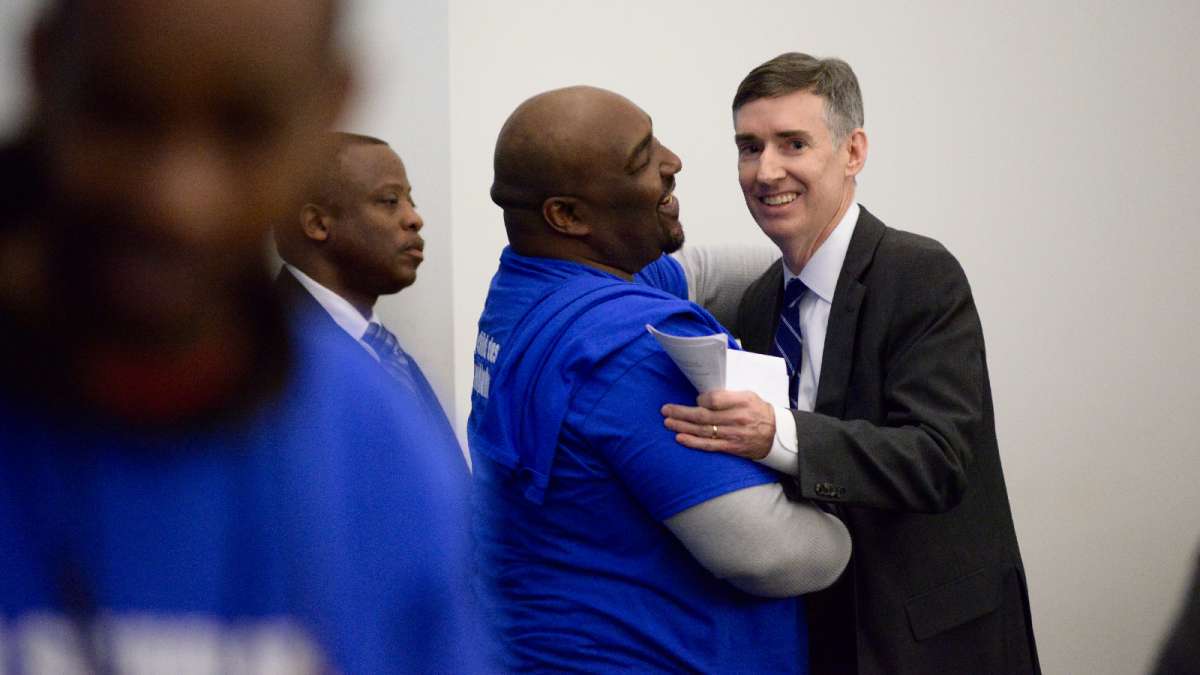 William Jackson embraces Mark Gleason, the executive director of the Philadelphia School Partnership. PSP had promised a $1.5 million grant to Wister if Mastery was given control.  (Bastiaan Slabbers for WHYY)