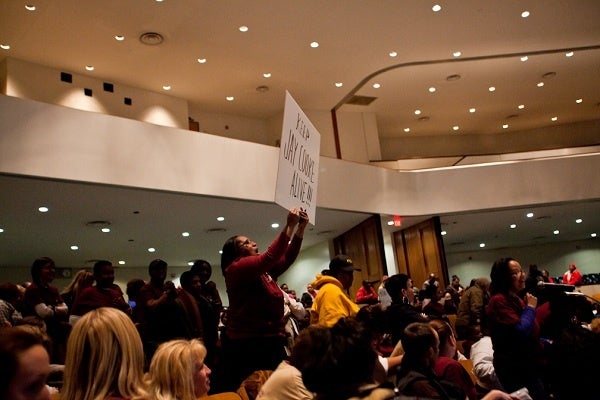<p><p>Leiya Bullock holds up a sign showing support for Cooke Elementary later in the meeting. (Brad Larrison/for NewsWorks)</p></p>
