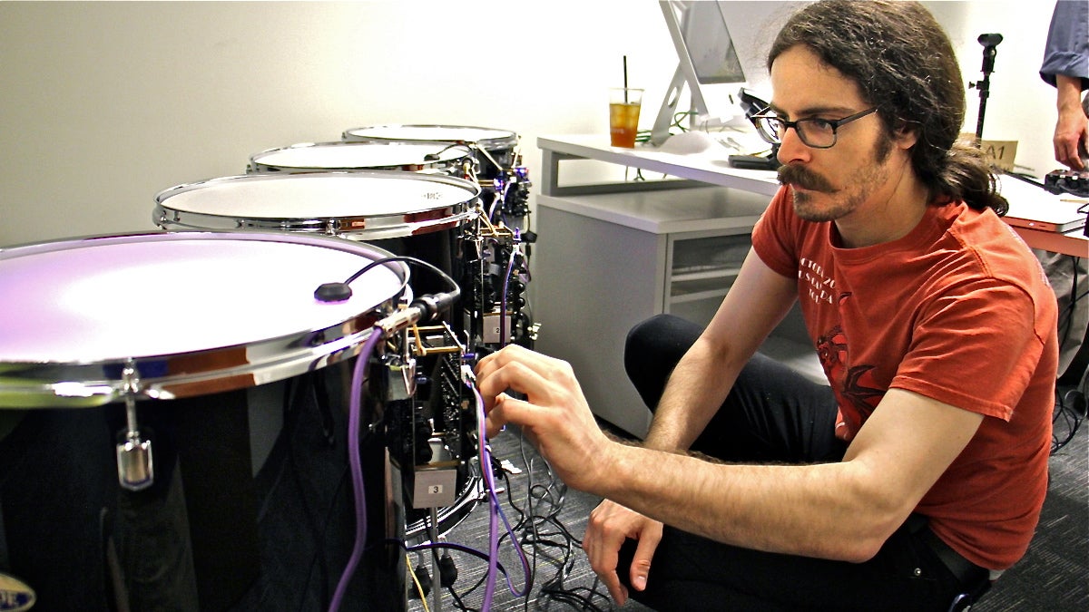  Drexel graduate student Jeff Gregorio connects an array of drums that are sounded by electromagnets. (Emma Lee/WHYY) 