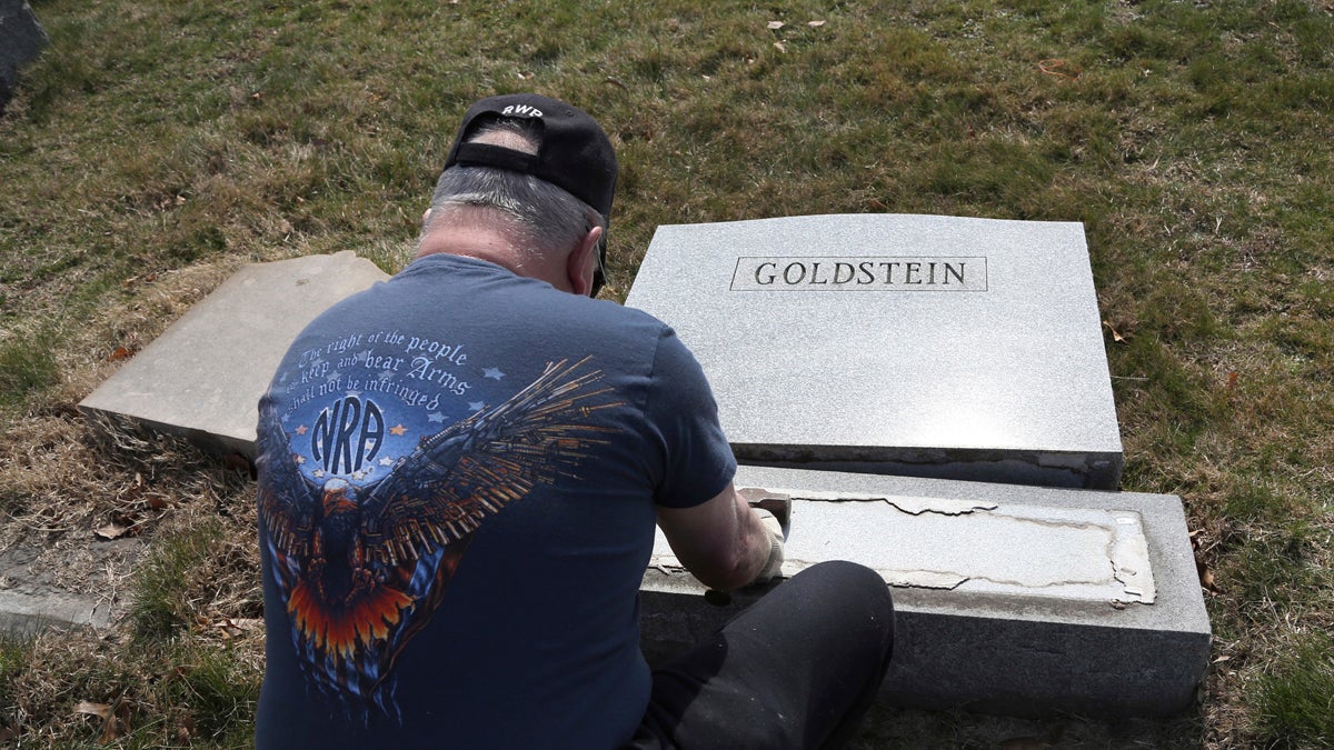  Trump supporter Bob, who declined to give his last name, volunteers his time and prepares the base of a damaged headstone Tuesday, Feb. 28, 2017, in Philadelphia. Scores of volunteers are expected to help in an organized effort to clean up and restore the Jewish cemetery where vandals damaged hundreds of headstones. (AP Photo/Jacqueline Larma) 