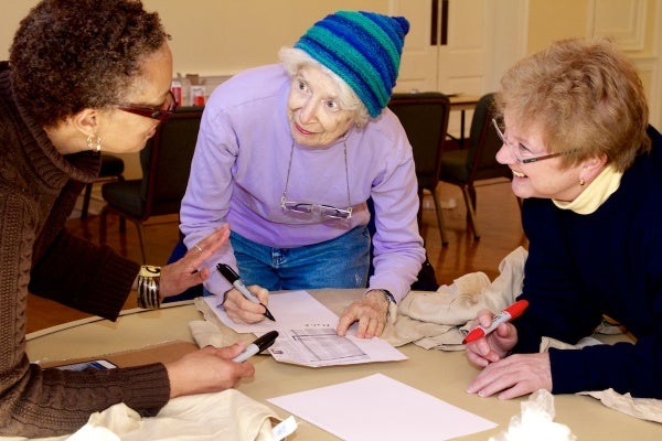 <p>With so many names to write, volunteers coordinate how best to ensure each victim is honored.  ( Jana Shea /for NewsWorks )</p>
