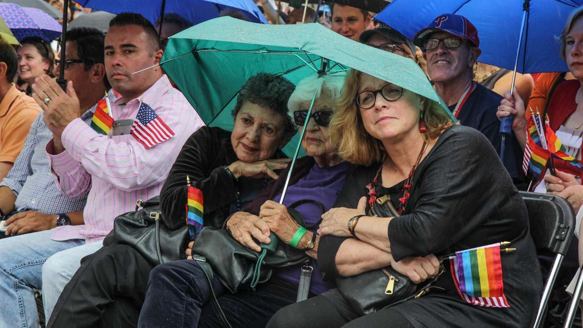 Lillian Faderman, Phyllis Irwin and Kathy hall share an umbrella at Philadelphia's 4th of July celebration of the 50th anniversary of the LGBT civil rights movement. (Kimberly Paynter/WHYY)