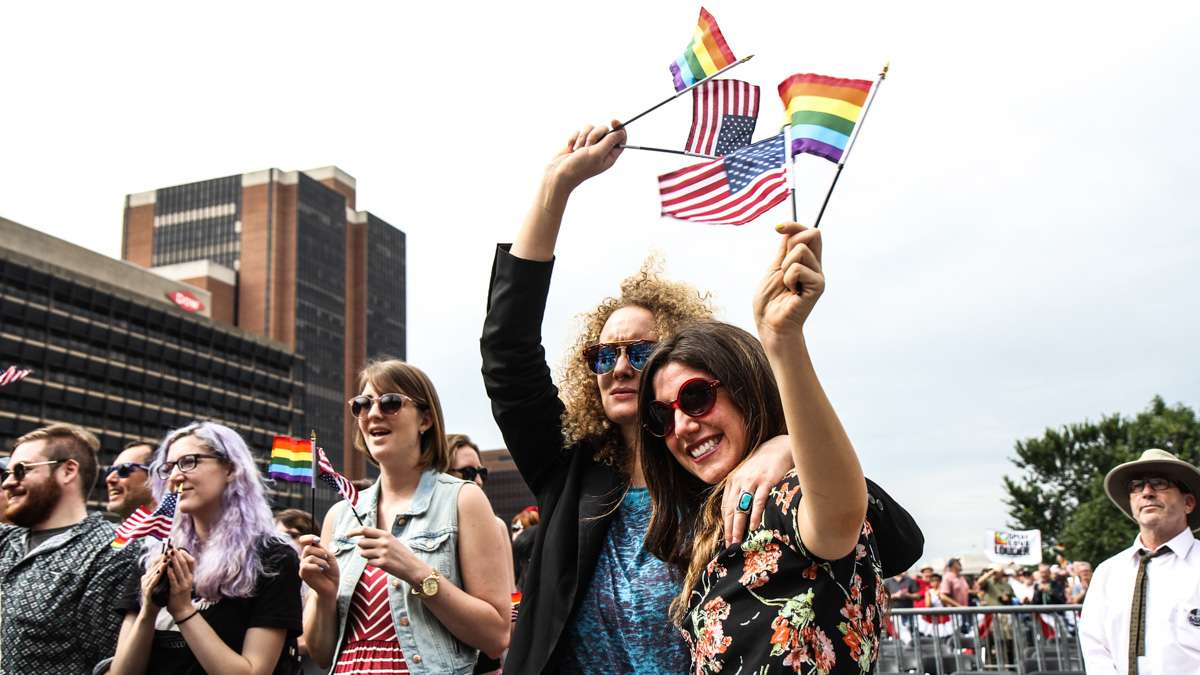Suanne Podzemny and Dassy Maisel wave flags during Philadelphia's 4th of July celebration of the 50th anniversary of the LGBT civil rights movement. (Kimberly Paynter/WHYY)