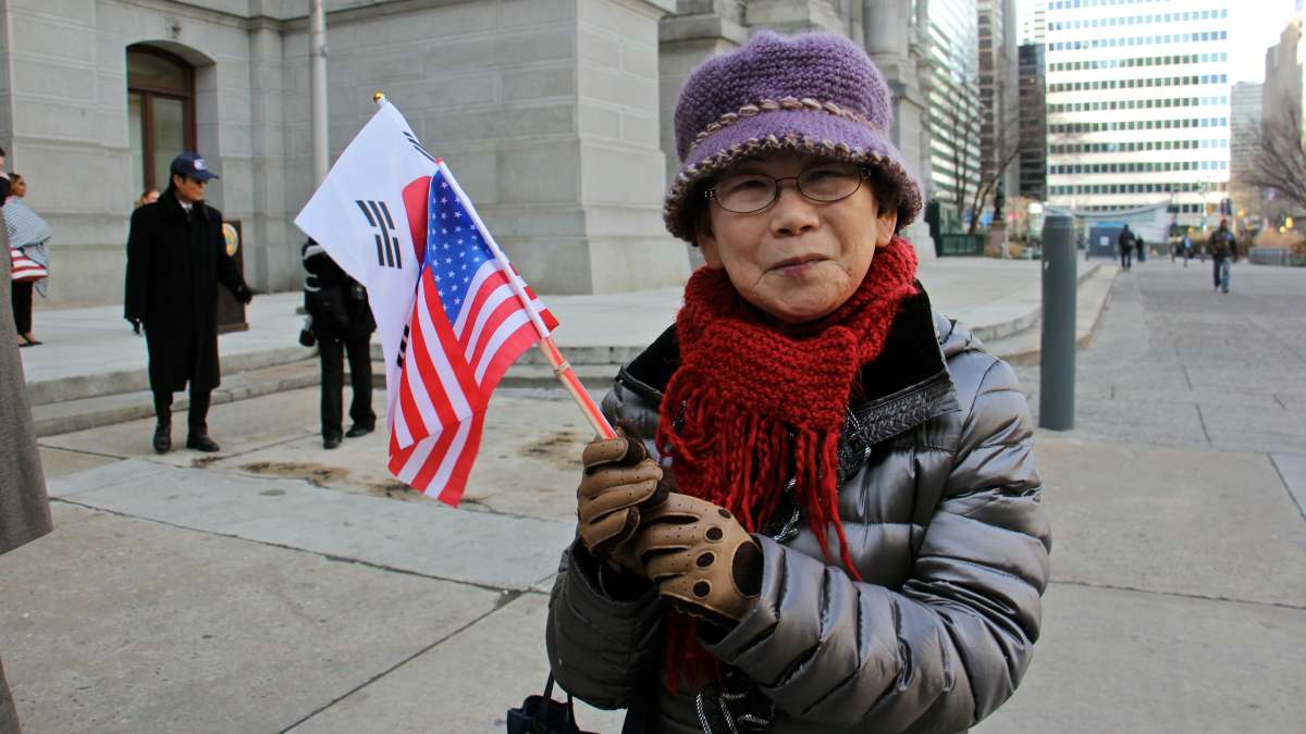 Joo Hwan Yi of Philadelphia waves the flags of the United Statesa and the Republic of Korea