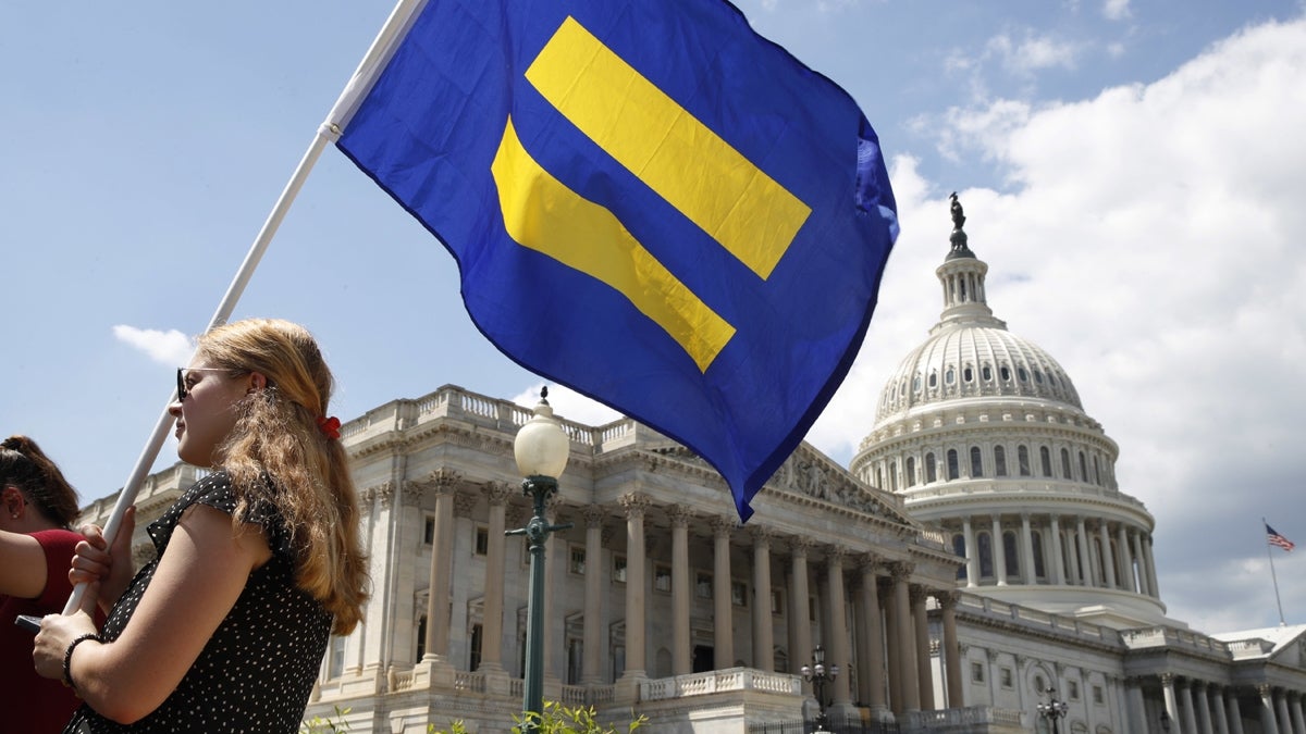 A supporter of LGBT rights holds up an 'equality flag' on Capitol Hill in Washington, Wednesday, July 26, 2017, during an event held by Rep. Joe Kennedy, D-Mass. in response to President Donald Trump's declaration that he wants transgender people barred from serving in the U.S. military 'in any capacity,' citing 'tremendous medical costs and disruption.' (Jacquelyn Martin/AP Photo)