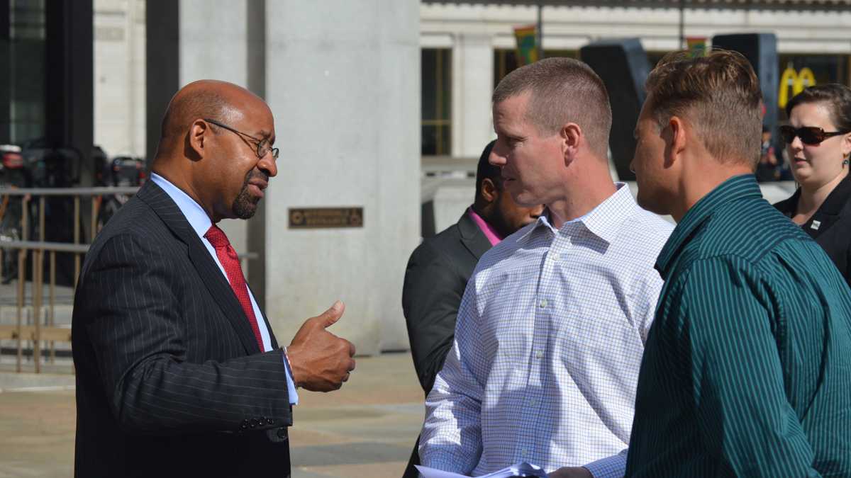  Mayor Michael Nutter, (left), speaks with Joe Schulle, head of the Philadelphia firefighters union Local 22, outside the Municipal Services Building in this file photo. (Tom MacDonald/WHYY)  