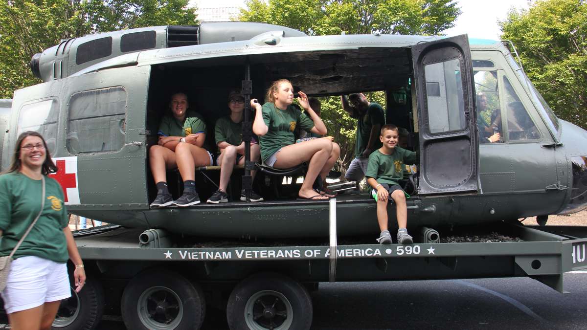 Children ride in a vintage helicopter in the Labor Day parade down Columbus Boulevard. (Emma Lee/WHYY)