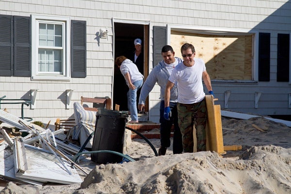 <p><p>Chandler Hosmer and neighbor Chris Carroll carry a broken table from the Hosmer home in Brighton Beach on Long Beach Island. (Lindsay Lazarski/WHYY)</p></p>
