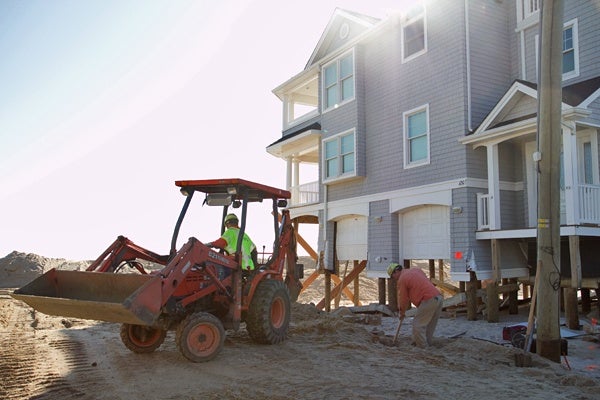 <p><p>Orlando Caceres (left) and Bill Callahan of PSEG dig through sand on Long Beach Island to disconnect a gas line of a beachfront property that will be demolished. (Lindsay Lazarski/WHYY)</p></p>
