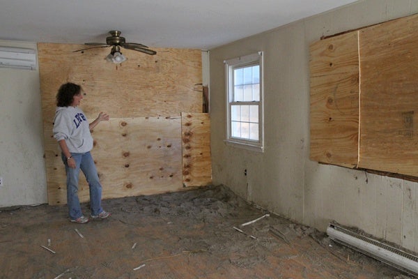 <p><p>Trish Hosmer shows where the neighbors' house crashed into her living room leaving a gapping whole. (Lindsay Lazarski/WHYY)</p></p>
