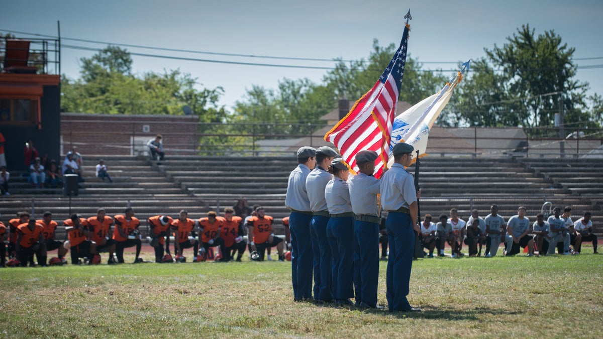 Junior ROTC members at Woodrow Wilson High School hold the American flag during the national anthem