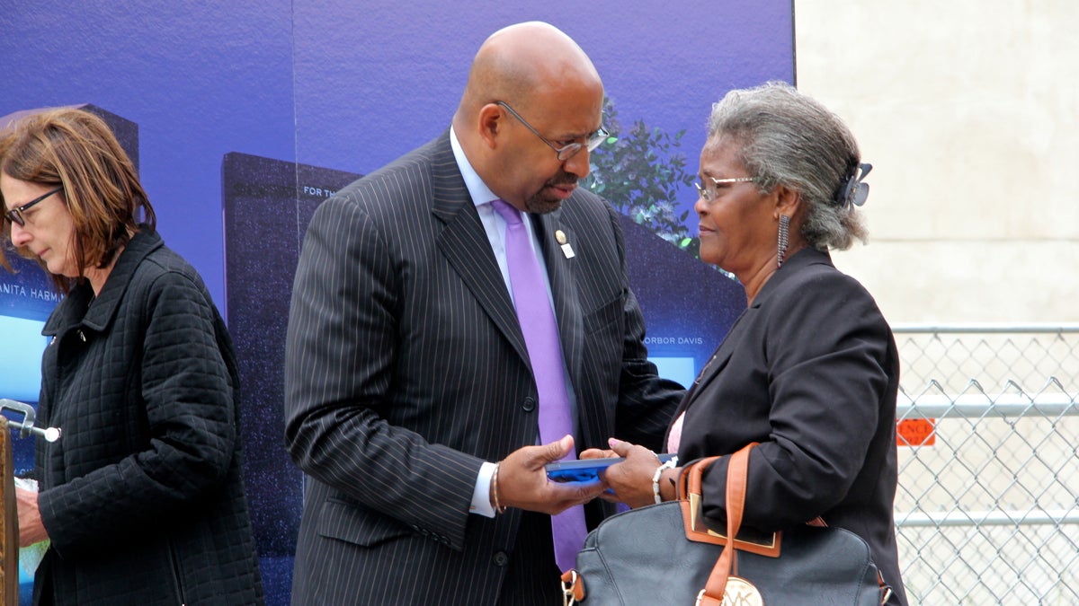 Mayor Michael Nutter presents a commemorative pane of glass to Maggie Davis, the widow of Borbor Davis, a Salvation Army employee who was killed in the collapse. (Emma Lee/WHYY)