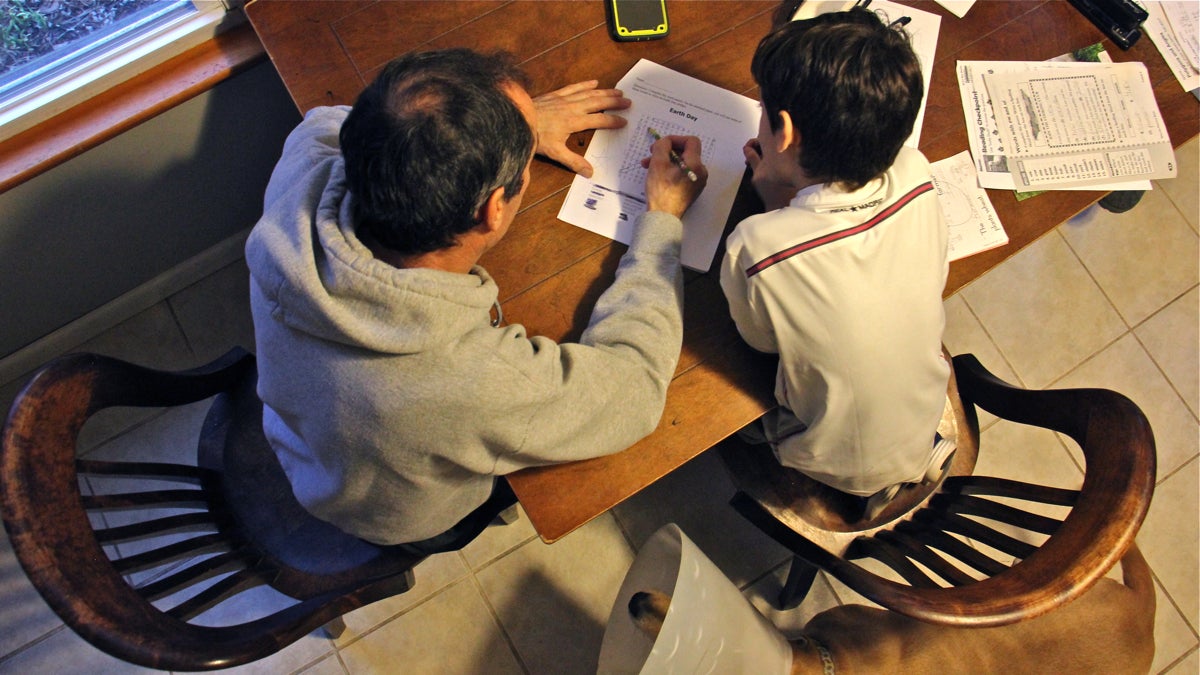 José helps his 7-year-old son with homework at their home in central New Jersey. (Emma Lee/WHYY)