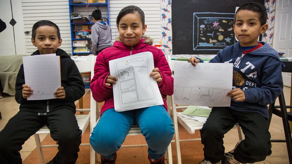  Siblings, Rogyer, 7, Jeidi, 8, and Romny, 7, show off their comics. Almost all of the comics the students have made illustrate the fear they have of ICE and the possible separation of their families. Mighty Writers El Futuro in South Philadelphia hosted a 10-class comic book workshop created by Nora Litz to help give their students a new outlet to talk about their fears after the 2016 elections. (Emily Cohen for NewsWorks) 