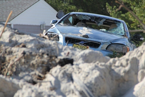 <p><p>A storm-battered car sits atop a pile of sand in a front yard on Bay Avenue in Holgate, N.J., the area of Long Beach Island hardest hit by Sandy. (Emma Lee/for NewsWorks)</p></p>

